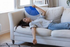 woman lying on a couch fanning herself