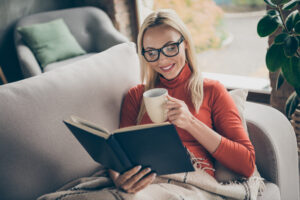 a woman reads a book while enjoying coffee